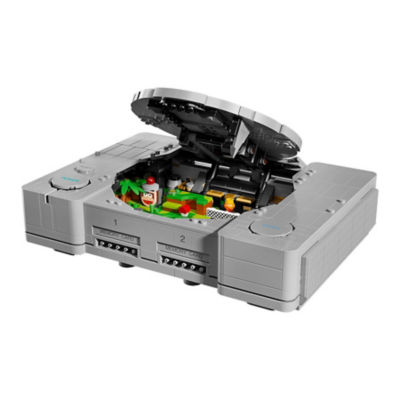 Aus LEGO Steinen gebaute originale PlayStation-Konsole mit geöffnetem Disc-Deckel, der eine farbenfrohe Miniaturszene im Inneren zeigt.