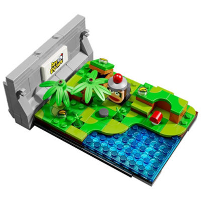 Von Ape Escape inspirierte LEGO-Miniaturszene mit tropischer Vegetation, blauem Wasser, einer Figur und einem Ape Escape-Schild.
