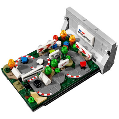 Von Gran Turismo inspirierte LEGO-Miniaturrennstrecke mit kleinen Autos, Barrieren, Bäumen und einem Gran Turismo-Schild.