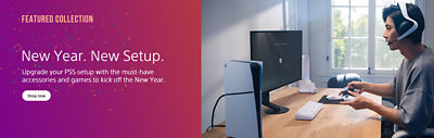 A PS5 gaming setup in a bright room: A PS5 console stands on a wooden desk next to a monitor, a white keyboard, and accessories. To the right, a person wearing a headset holds a DualSense controller. To the left, the confetti-filled gradient background shows the text “New Year. New Setup.” and “Upgrade your PS5 setup with the must-have accessories and games to kick off the New Year.”