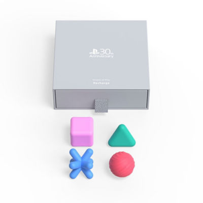 The grey box packaging alongside the pink square, green triangle, red circle and blue cross silicone shapes