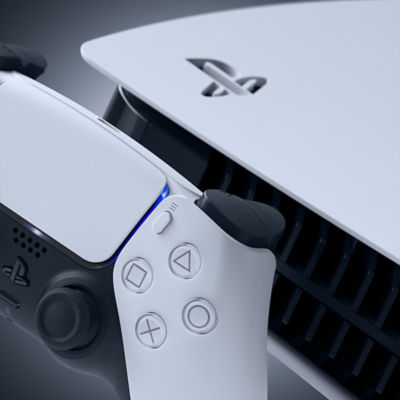 Close-up de um controle DualSense e parte do console PlayStation 5, mostrando o logotipo do PlayStation e detalhes de design em branco e preto.