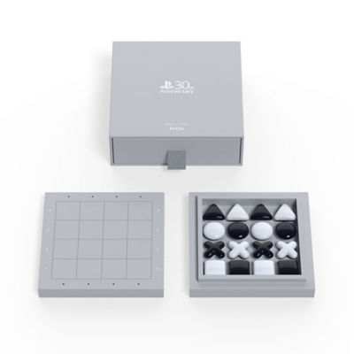 The grey box packaging alongside a grey game board and black and white PlayStation Shapes pieces