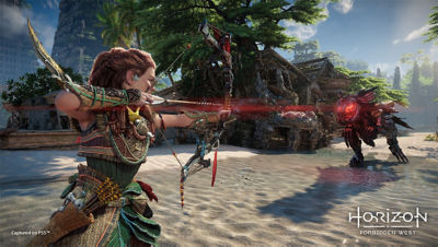 Aloy zielt mit einem Pfeil auf eine Maschine am Strand