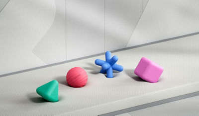 The green triangle, red circle, blue cross, and pink square silicone shapes on top of grey material