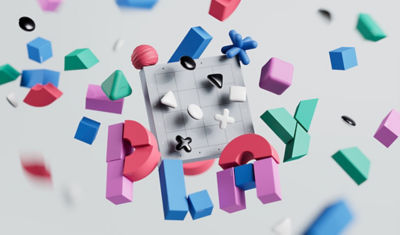 Silicone shapes alongside multicoloured magnetic blocks spelling the word Play, and black and white game pieces