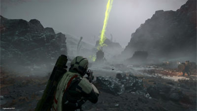 Un Helldiver sur un champ de bataille parsemé de rochers, avec des traits de lumière verte dans le ciel