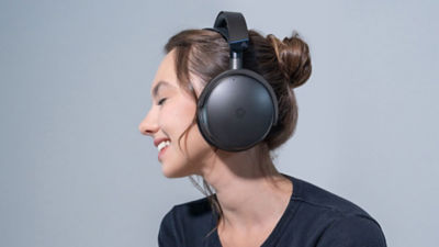 Person smiling while wearing the Audeze Maxwell 2 wireless headset.