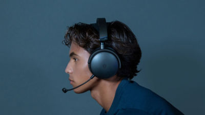 Side profile of person wearing the Audeze Maxwell 2 headset with boom microphone extended.