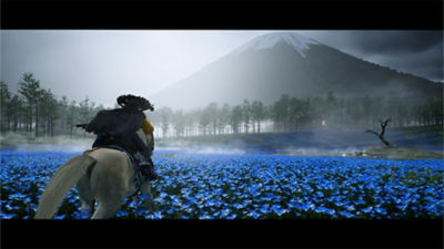 Atsu riding through a field of blue flowers