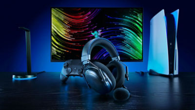 Razer headset and a Razer controller in front of a colourful lit monitor