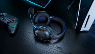 Razer BlackShark Headset laying flat on a desk surrounded by accessories and PS5