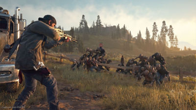 Days Gone star Deacon St. John stands on a field and points a rifle at a horde of zombies coming after him.