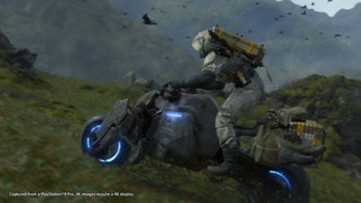 PS4 Death Stranding Game star, Sam Bridges, races across an open field on a motorcycle while dressed in a hazmat suit